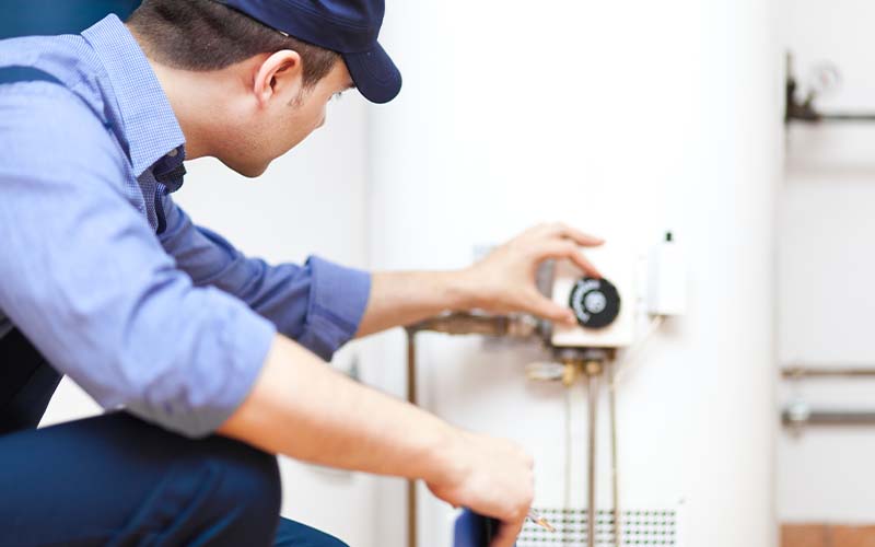 AC tech repairing an hot-water heater