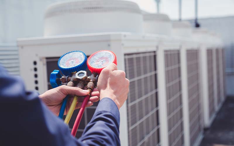 AC Technician is checking air conditioner ,measuring equipment for filling air conditioners.C